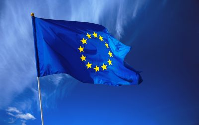 Flag of the european union in front of the deep blue sky.